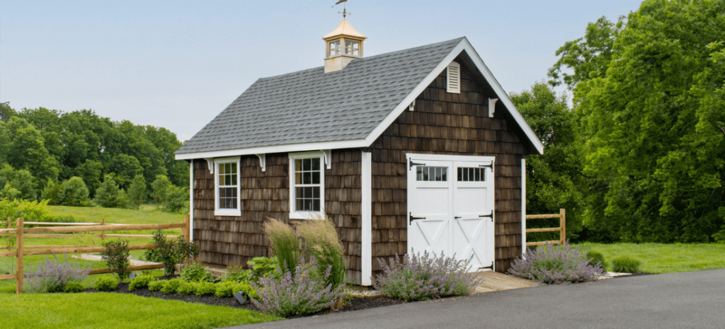 Wooden shingle shed with white doors in te country side